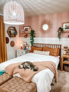 a cat laying on top of a bed in a room with pink walls and wooden furniture