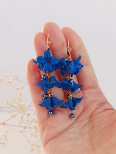 https://purplebeestudio.etsy.com Handmade polymer clay very elegant chandelier earrings. These elegant earrings in trendy cobalt blue colour will become your favorits for many occasions day or night.  Perfect gift for a special woman in your life. The flowers are made by hand by me without using any molds. Earrings made with brass ear wire. The earrings are very light and comfortable to wear all day. SHIPPING: Your order will be dispatched in a securely packed cardboard box. Product care:  - To ensure the product quality and durablility, avoid contact with water, lotion, perfumes and household cleaners and chemicals. - You can clean the products with a slightly damp soft fabric.  - Sharp objects can damage the clay surface. - When not in use, store in a dry, seperate box. Thank you for vis Blue Dangle Flower Earrings In Polymer Clay, Elegant Blue Polymer Clay Earrings, Cobalt Blue Earrings, Elegant Earrings, Blue Earrings, Flower Jewellery, Handmade Polymer Clay, Cobalt Blue, Handmade Flowers