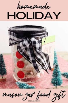 a jar filled with chocolate covered pretzels on top of a red table cloth