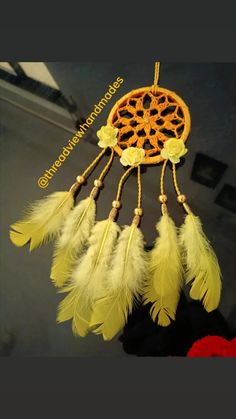 an orange and white dream catcher with feathers