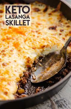 a close up of a casserole in a pan with a spoon on it