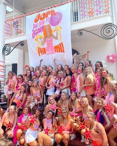 a group of young women standing next to each other in front of a white building