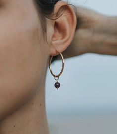 Complete your look with this ethically handcrafted set of 2 dainty, gold tone on brass hoops. Featuring a braided style and a hoop with a semiprecious amethyst bead, these simple styles can be worn alone or together for a effortless minimalist, day to evening transition. Item Details: Set of 2 Small Hoops: .75" L .75" W Large Hoops: 1" L 1" W We began in 2006 with the mission of creating opportunities for marginalized producers to realize their creative, economic and leadership potential. Since Brass Hoop Earrings, Brass Hoops, Gardening Outfit, Hoop Earring Sets, Drop Beads, Amethyst Beads, Novelty Items, Cosmetic Case, Gold Hoop