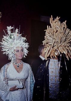 two people dressed in costume and headdress standing next to each other