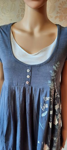 a mannequin wearing a blue top with buttons on it's chest and neck