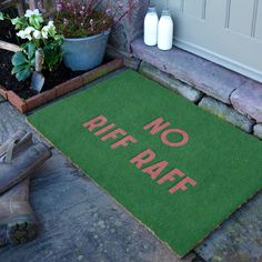 a door mat that says no raff on it next to some flowers and plants