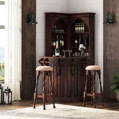 two bar stools in front of a wooden cabinet with wine bottles on it and an area rug