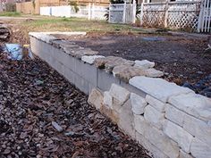 a stone wall in the middle of a yard