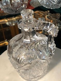 a clear glass vase sitting on top of a white table next to other glass dishes