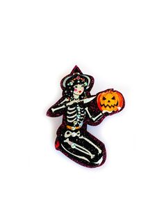 a pin with a skeleton holding a pumpkin