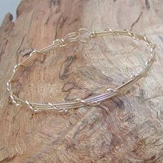 A pretty little bracelet of four strands of 14kt gold filled--three plain square wires, overwrapped with one strand of twist wire. Charming and feminine, and perfect to wear every day. Stackable with so many of my other wirewrapped bracelets! What a sweet graduation gift for a special young lady! Or just as nice for a birthday, Christmas, or Hanukkah. Of course, you can always treat yourself as well! The sturdy built-in hook and eye clasp is easy to get on and off by yourself. Choose your size f Adjustable Gold Sterling Silver Bangle, Adjustable Yellow Gold Wire Wrapped Bracelets, Adjustable Gold Sterling Silver Delicate Bracelet, Gold Wire Wrapped Wrap Bracelet As A Gift, Gold-plated Nickel-free Sterling Silver Bangle, Gold Sterling Silver Nickel-free Bangle, Delicate Adjustable Wire Wrapped Bracelets, Teen Jewelry, Wire Bangles