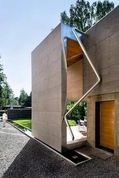 an unusual house in the middle of a gravel lot with stairs leading up to it