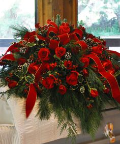 a casket with red flowers and greenery