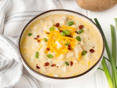 a bowl of soup with cheese and green onions