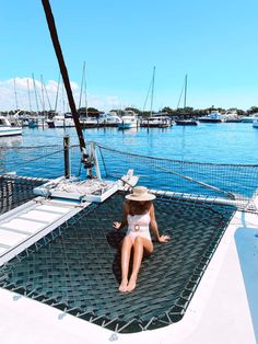 a woman sitting on top of a hammock in the water