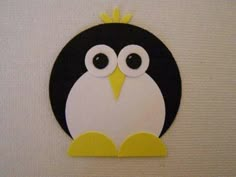 a black and white penguin with a yellow crown on it's head is standing in front of a wall