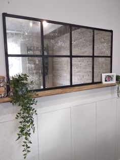 a window that has some plants on the ledge in front of it and a potted plant next to it