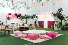 an indoor party with pink and purple balloons