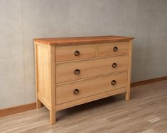 a wooden dresser sitting on top of a hard wood floor next to a white wall