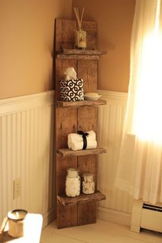 a wooden shelf with towels on top of it next to a window in a room