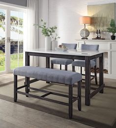 a dining room table with four chairs and a bench