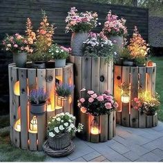 several wooden planters filled with flowers and lit candles