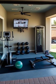 a home gym with exercise equipment in the background and a flat screen tv on the wall