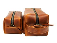 two brown leather bags with zippers on them