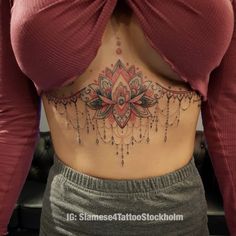 a woman's stomach with an intricate tattoo design on the bottom and back side