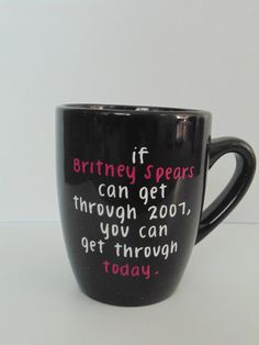 a black coffee mug with pink writing on it that says, if battery spears can get through 2001, you can get through today