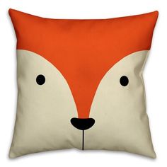 an orange and white pillow with a fox's face on the front, it has black eyes