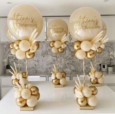 some balloons that are sitting on top of a white table with gold foil balls in them