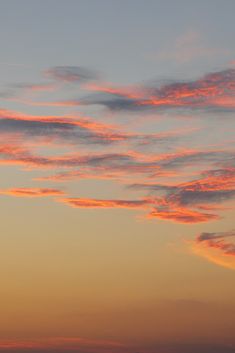 an airplane is flying in the sky at sunset