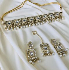 Our exquisite Square-shaped Choker Necklace Set is adorned with delicate pearls, adding a touch of timeless grace to your look. Paired with matching earrings that elegantly frame your face and a Tikka to complete, this set is perfect for all Desi occasions and features intricate Kundan work. Available now in both radiant gold, and bright yellow colors! Whether you're a bride looking for the perfect finishing touch or just attending a special celebration, this set promises to enhance your beauty and make a lasting impression. Elegant Pearl Jewelry Set For Gift, Festive Pearl Sets As Gifts, Festive Pearl Sets For Gift, Elegant Pearl Sets With Stone Work, Festive White Pearl Sets, Elegant White Pearl Sets, Desi Jewelry, Jewelry Kundan, Kundan Work