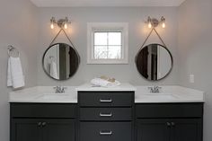 a bathroom with two sinks and three mirrors