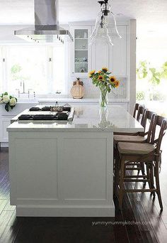 a kitchen with white cabinets and wooden floors