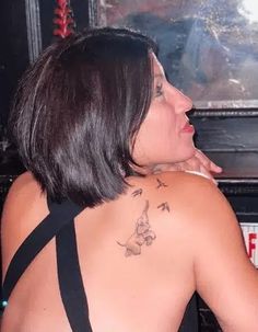 the back of a woman's body with tattoos on her upper and lower half