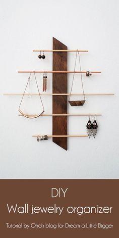 a wall mounted jewelry rack with earrings hanging from it's sides and wooden shelves