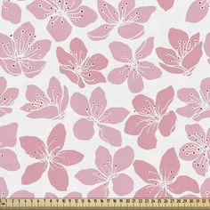 a pink and white flower print fabric with small dots on the bottom, in front of a ruler