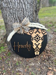 a wooden sign with the word hodgy written on it next to a tree