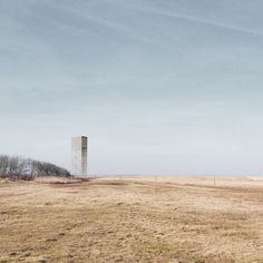 an empty field with a tall tower in the distance