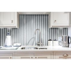 a kitchen with white cabinets and stainless steel faucet in the middle of the counter