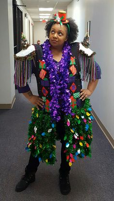 a woman dressed in an elaborately decorated costume poses for a photo while standing in the hallway