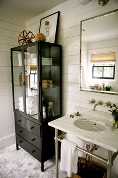 a bathroom with a sink, mirror and cabinet in it's centerpieces