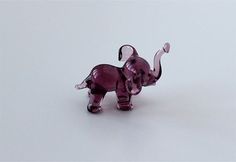 an elephant figurine sitting on top of a white surface