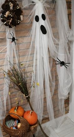 halloween decorations on the front porch with ghost net and pumpkins