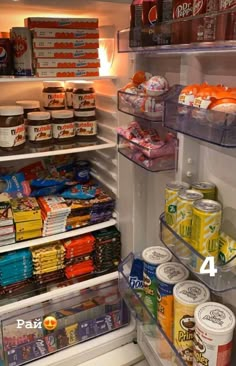 an open refrigerator filled with lots of food and drink items, including cans of soda