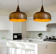 two pendant lights hanging over a kitchen island