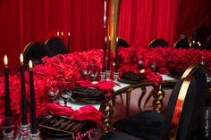 the table is set with black and red plates, silverware, and napkins