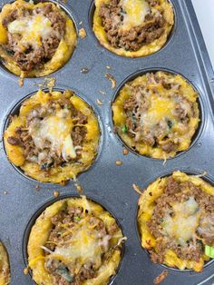 a muffin tin filled with taco meat and cheese